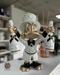 Dagobert Duck im Anzug von Louis Vuitton und mit Champagner von Moët & Chandon