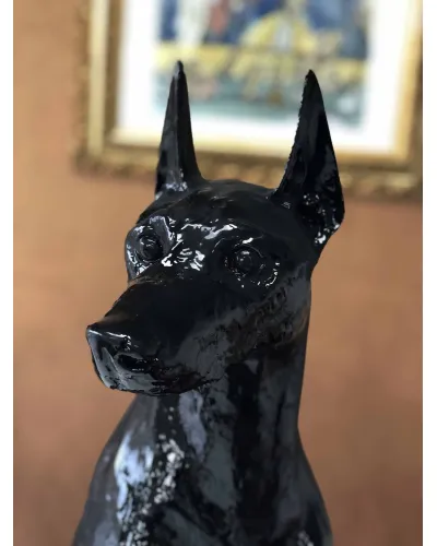 Doberman assis noir en résine polyester résistant au gel, à la pluie et aux UV du soleil.